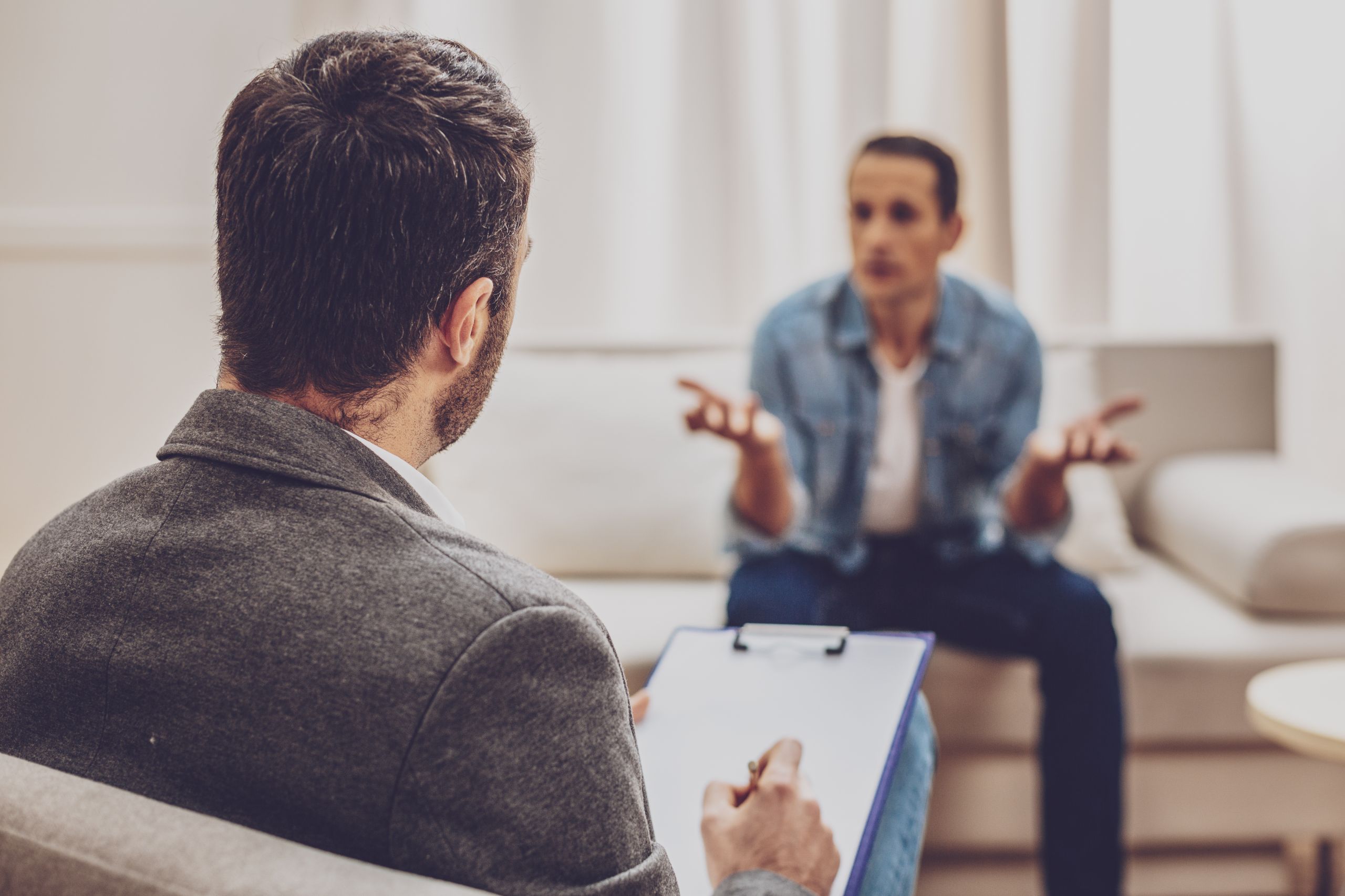 Frustrated young man speaking with psychologist