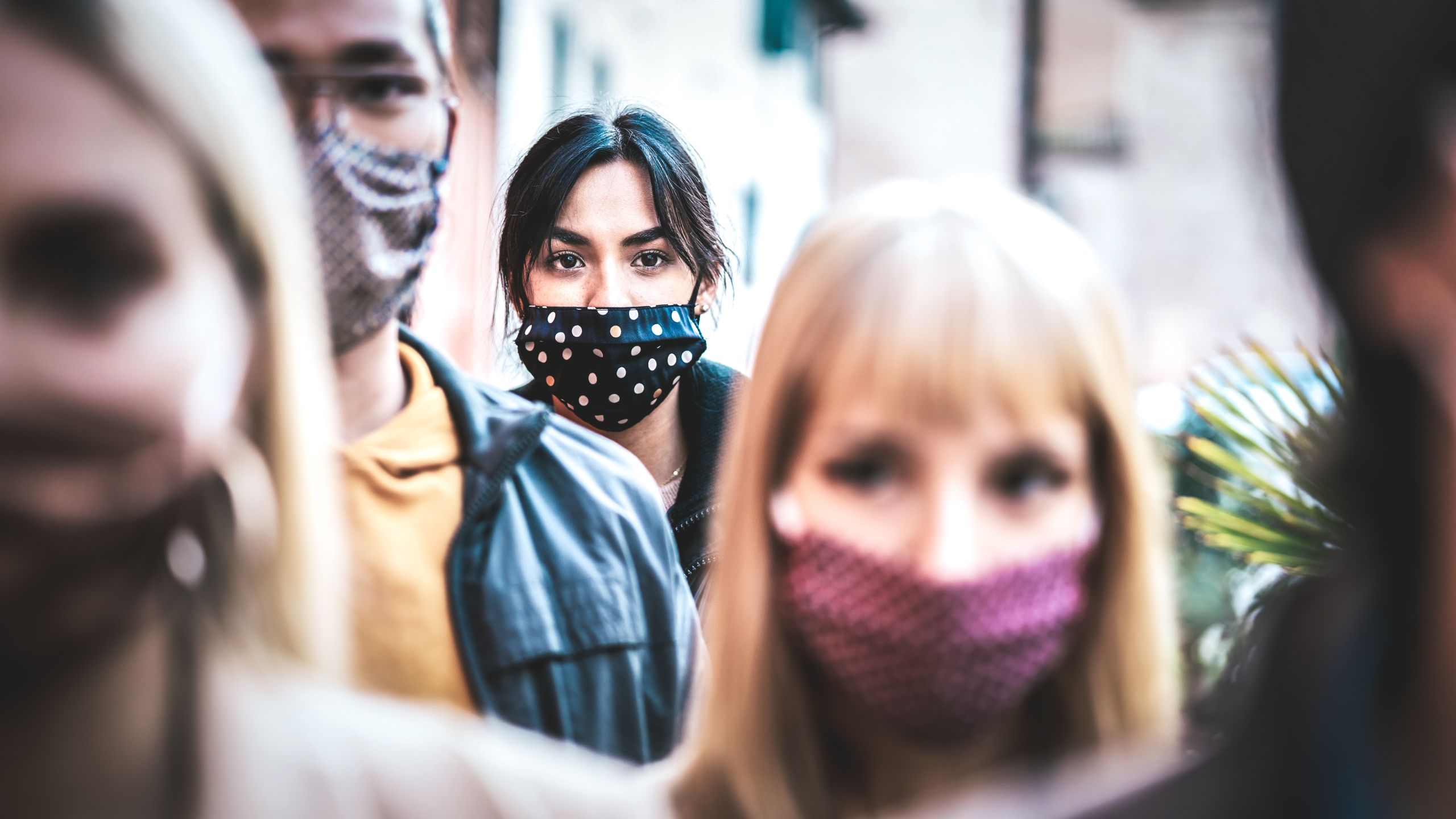 Urban commuter crowd of people moving on city street covered by face mask - New normal human condition and society concept - Focus on middle woman wearing black facemask - Desaturated contrast filter