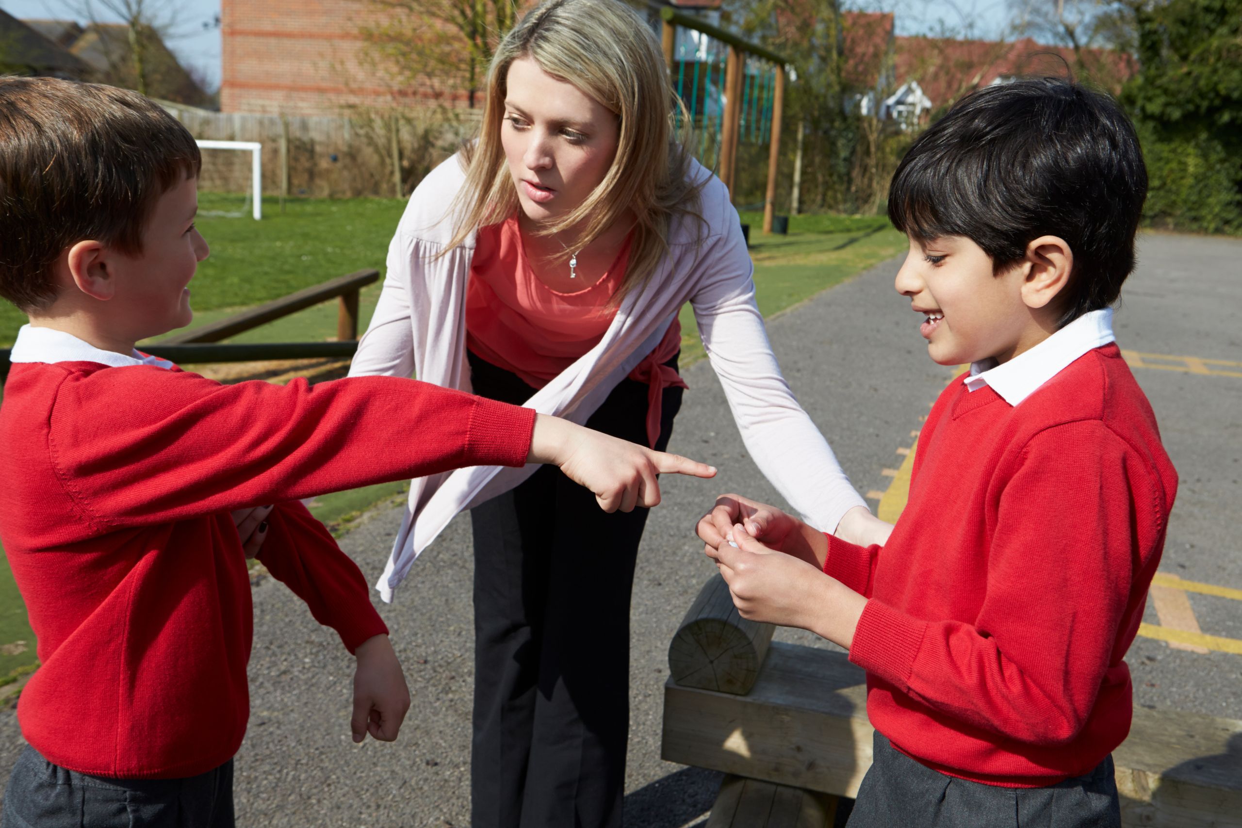 Teacher Stopping Two Boys Fighting In Playground