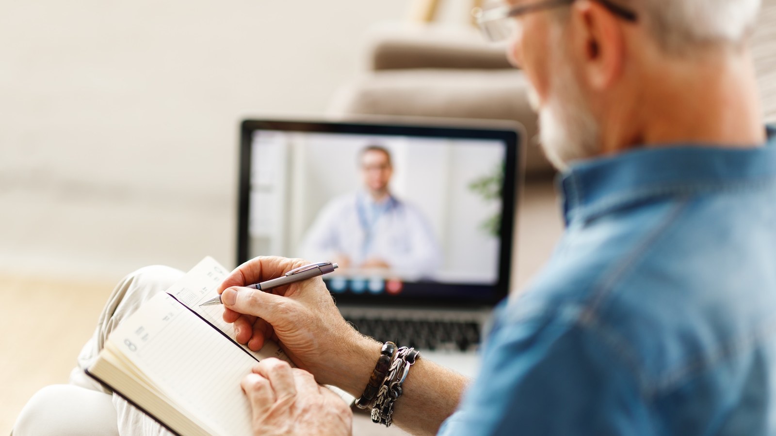 Patient taking notes during a telehealth psychiatry appointment